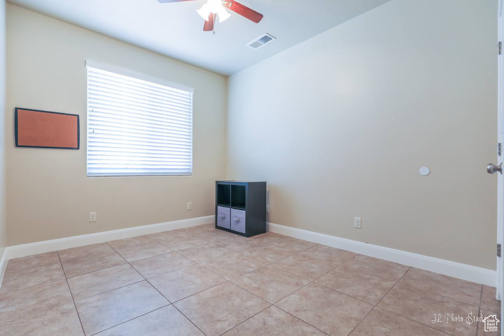 Spare room with light tile floors and ceiling fan