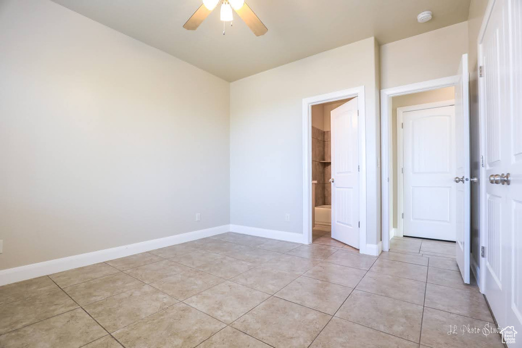 Unfurnished bedroom featuring ceiling fan, a closet, and light tile floors