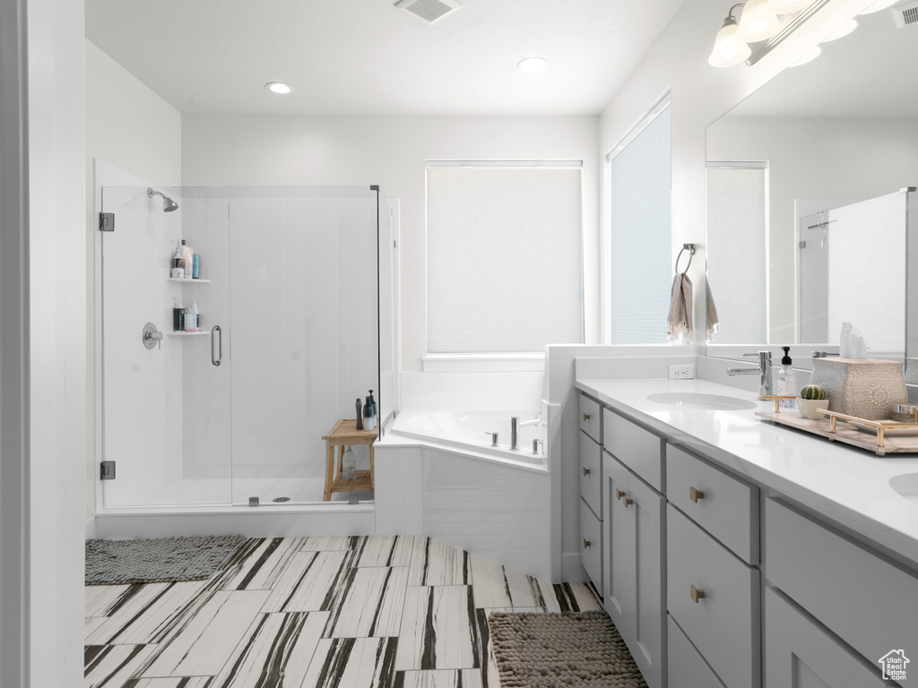 Bathroom with tile flooring, plus walk in shower, and vanity