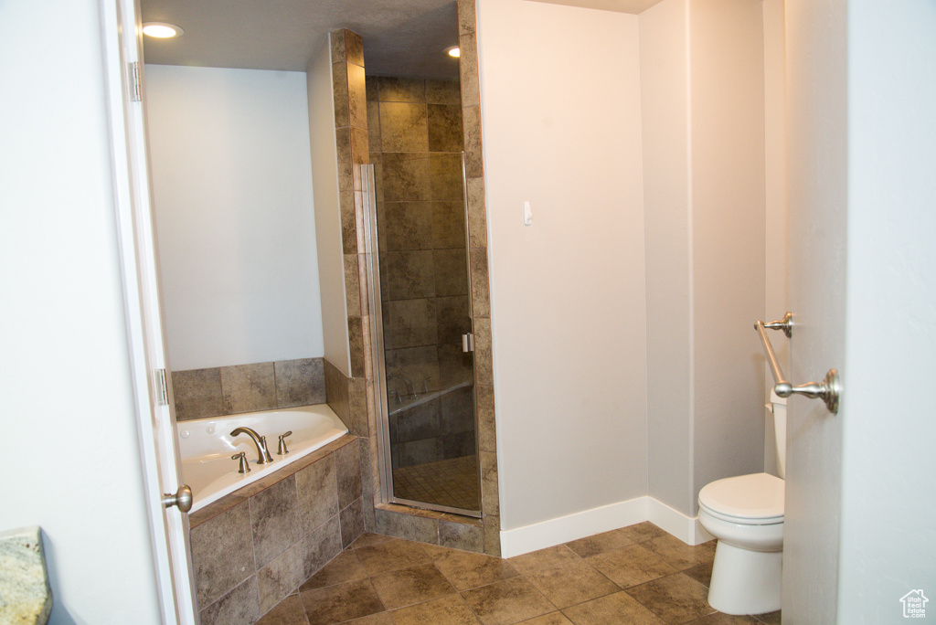 Bathroom with toilet, tile flooring, and separate shower and tub
