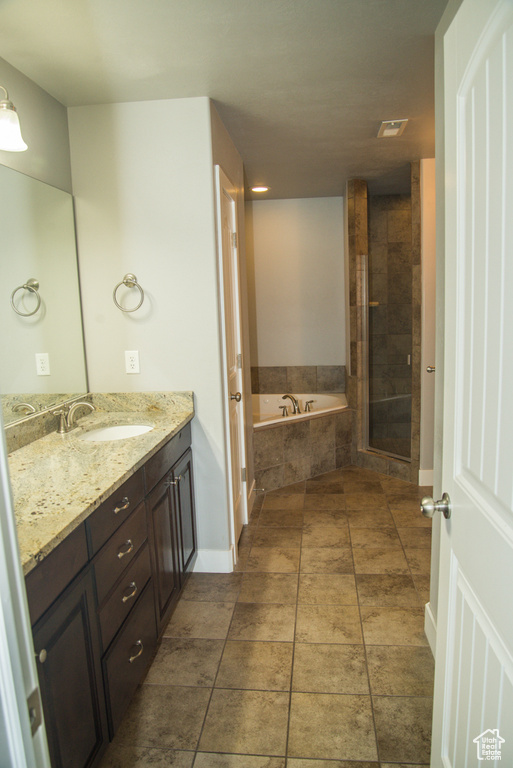 Bathroom featuring vanity, plus walk in shower, and tile flooring