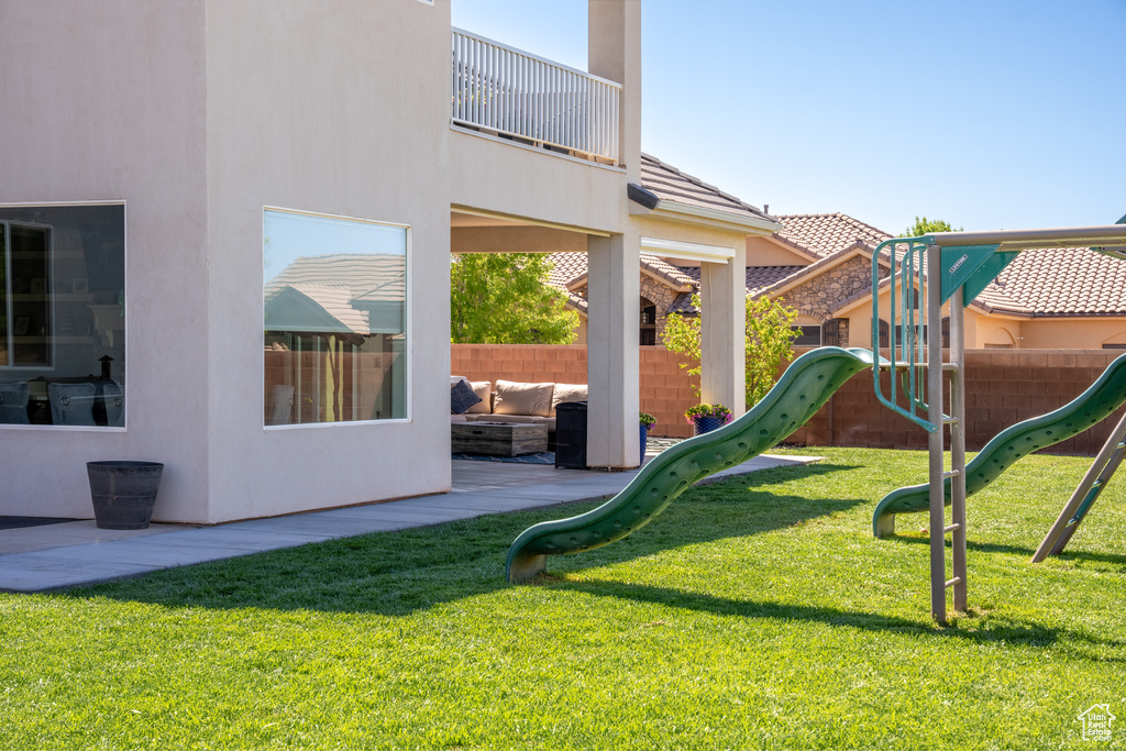 View of jungle gym featuring a patio area and a yard