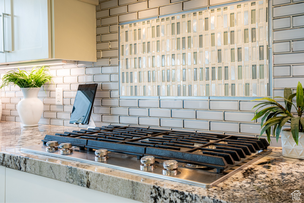 Room details with backsplash and stainless steel gas stovetop
