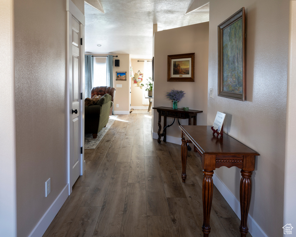 Hallway featuring hardwood / wood-style floors and a textured ceiling