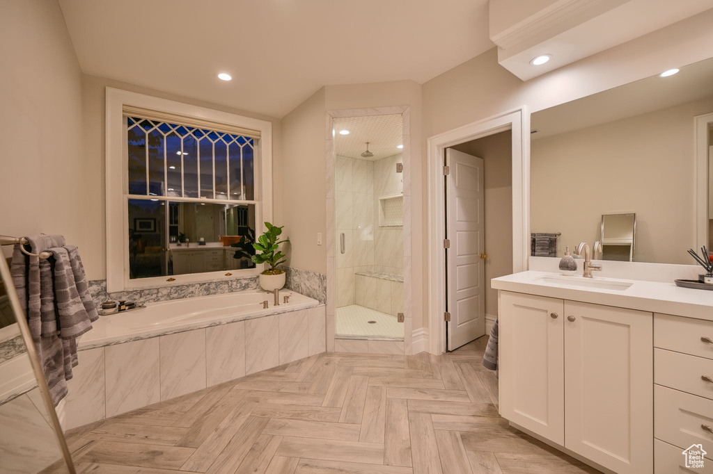 Bathroom with oversized vanity, separate shower and tub, and parquet floors