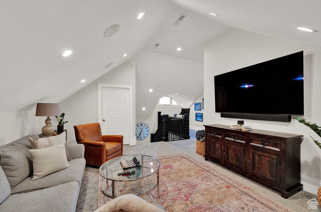 Living room with vaulted ceiling and light colored carpet