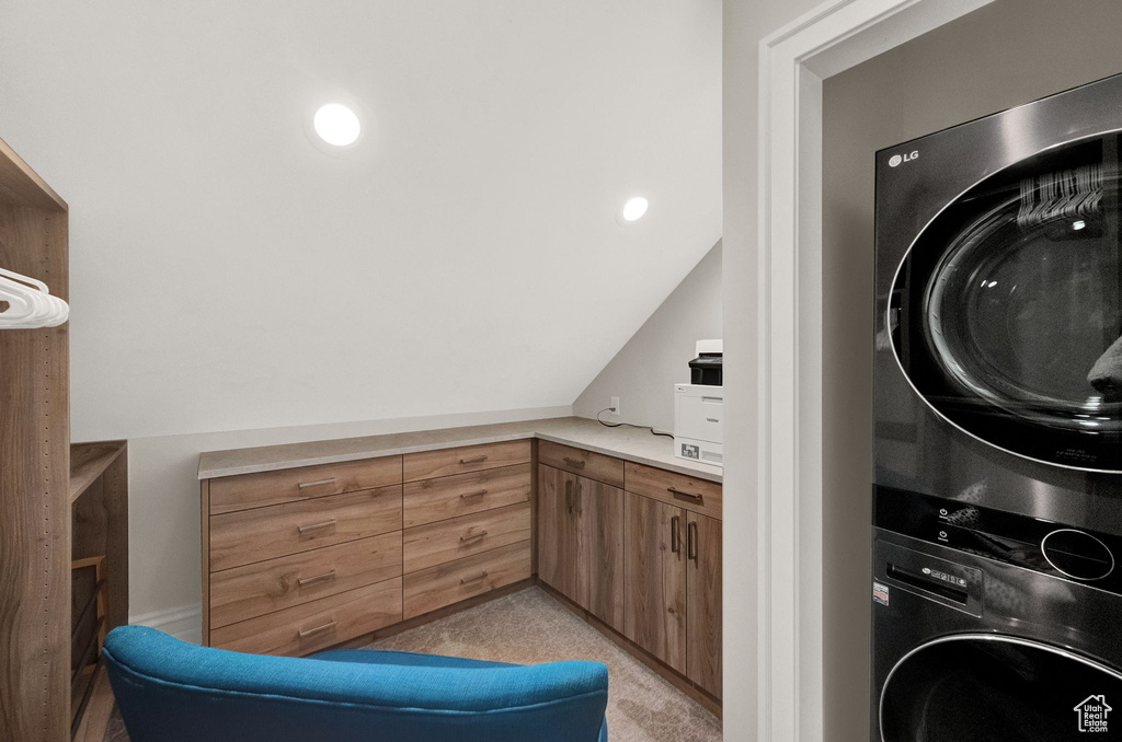 Washroom with light colored carpet and stacked washer and dryer