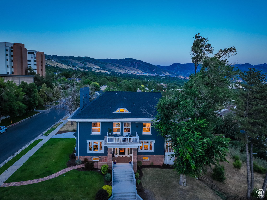 Exterior space with a balcony, a lawn, and a mountain view