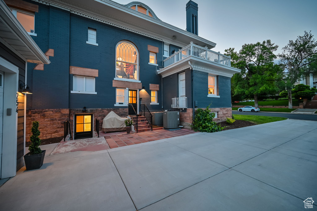 Rear view of house featuring a balcony and central AC unit