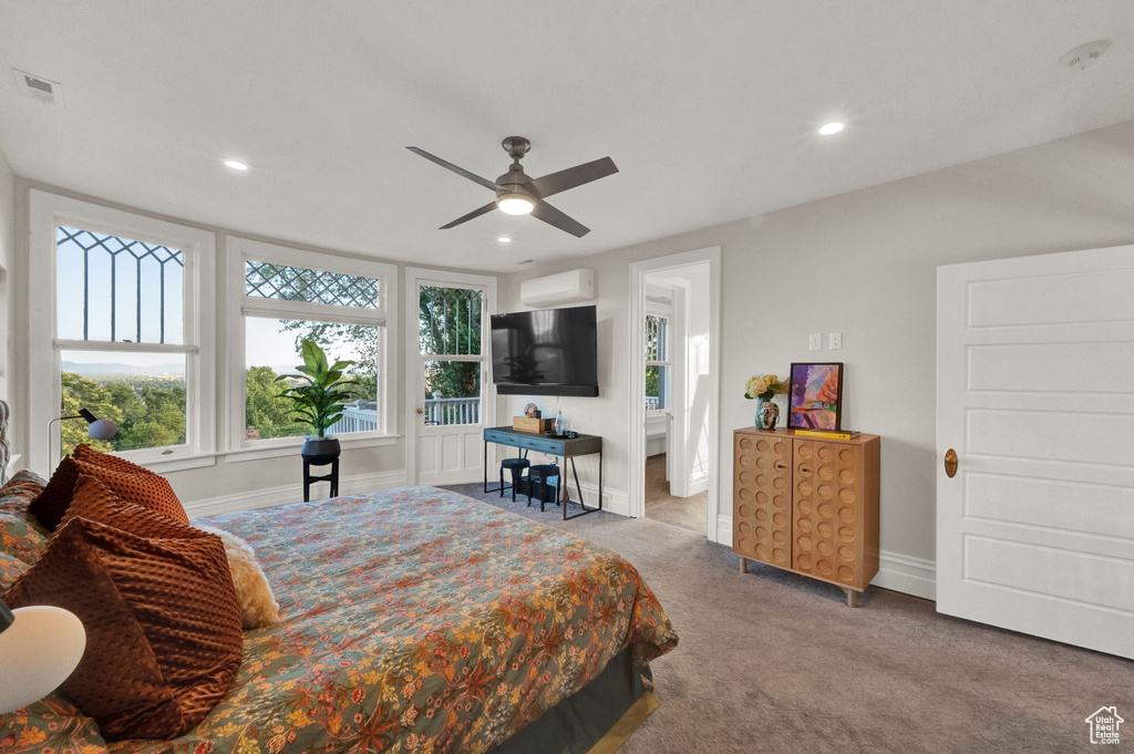 Carpeted bedroom featuring ceiling fan and a wall unit AC