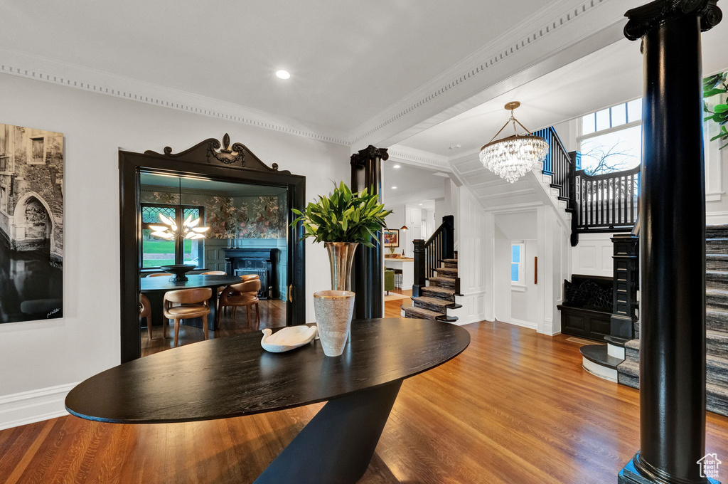 Dining room featuring an inviting chandelier, hardwood / wood-style floors, and ornamental molding