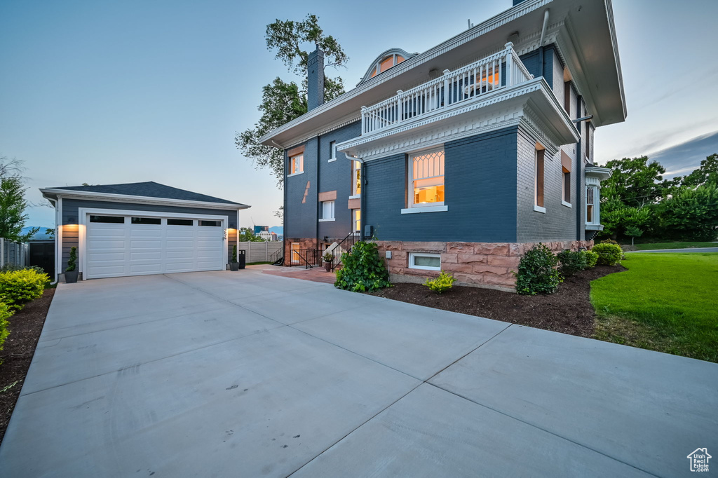 View of front of home with a balcony and a front yard