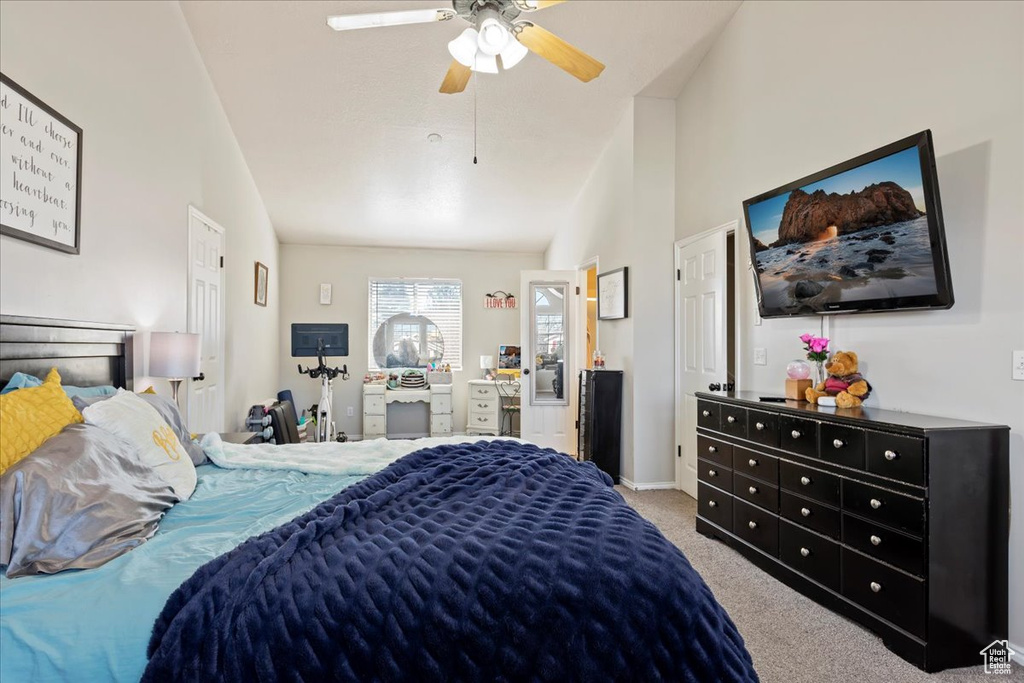 Bedroom featuring ceiling fan, vaulted ceiling, and dark colored carpet
