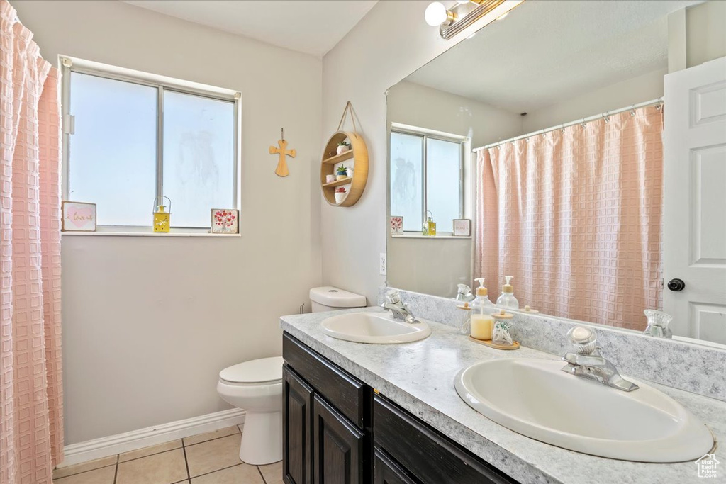 Bathroom featuring double sink, plenty of natural light, tile flooring, and large vanity