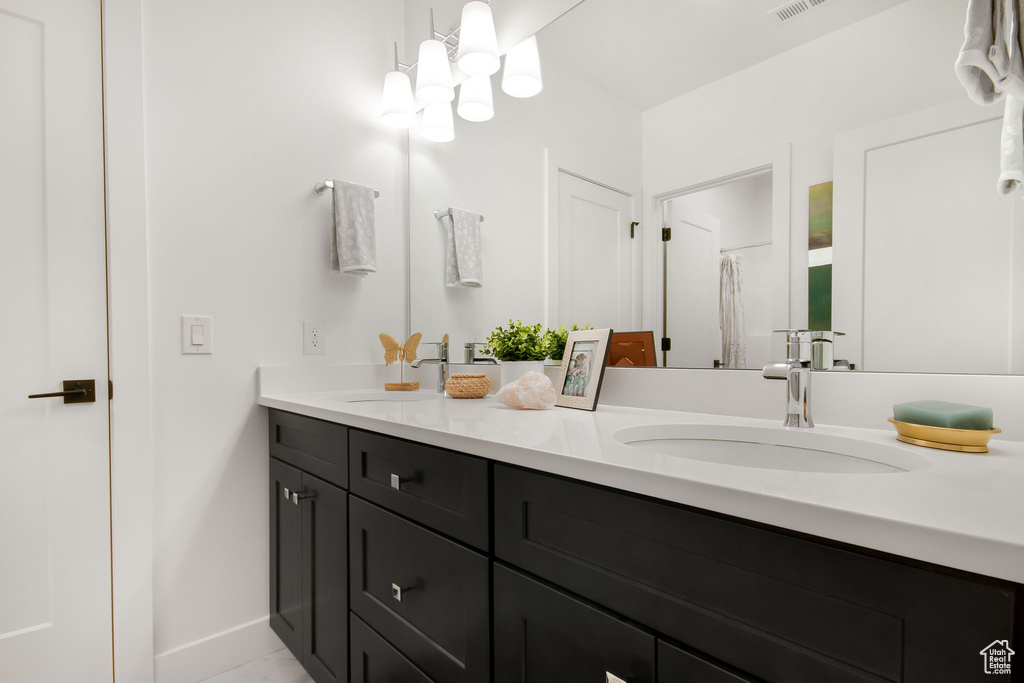 Bathroom with dual vanity and an inviting chandelier