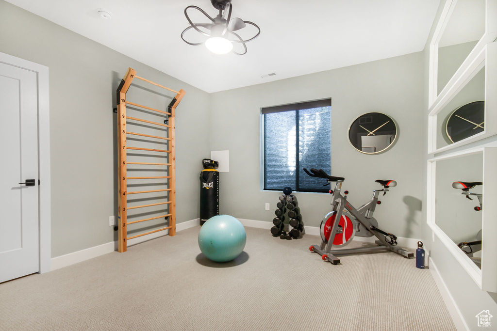 Exercise area with light carpet and ceiling fan
