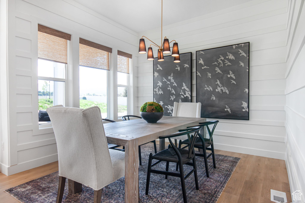 Dining area with a notable chandelier and light hardwood / wood-style flooring