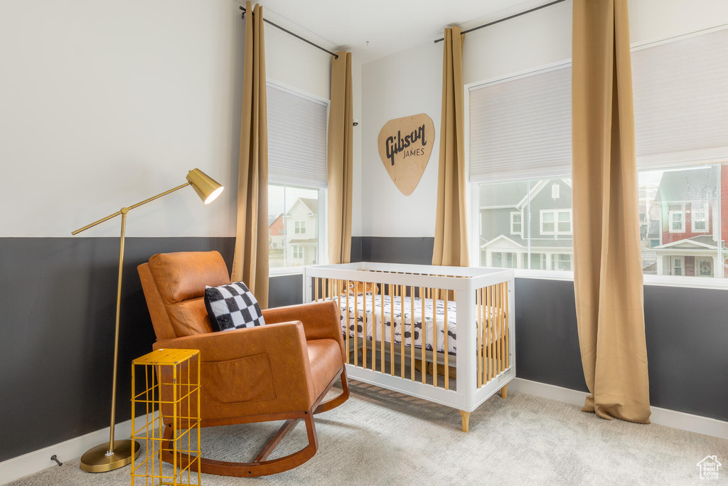 Bedroom with a nursery area and light colored carpet