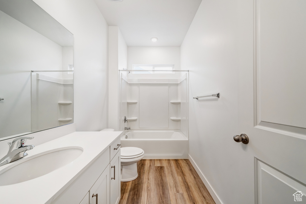 Full bathroom featuring vanity, hardwood / wood-style floors, toilet, and bathing tub / shower combination