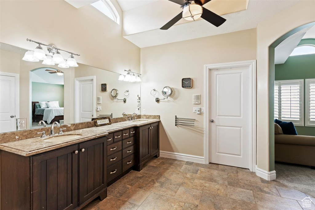 Bathroom featuring ceiling fan, large vanity, tile flooring, and dual sinks