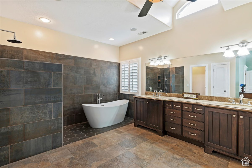 Bathroom with plenty of natural light, oversized vanity, tile floors, and double sink