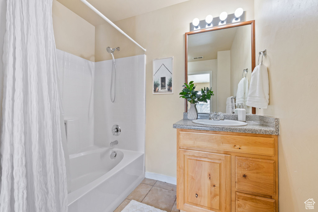 Bathroom featuring shower / bathtub combination with curtain, large vanity, and tile flooring