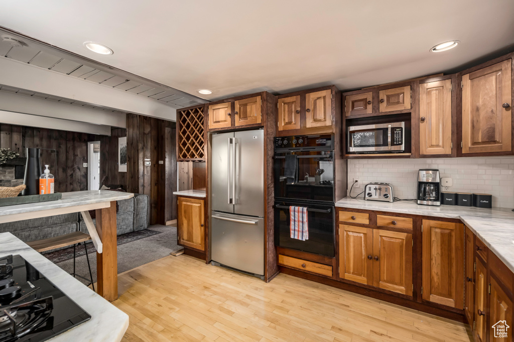 Kitchen with light hardwood / wood-style flooring, tasteful backsplash, and stainless steel appliances