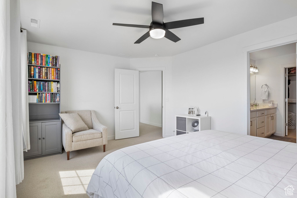 Bedroom featuring connected bathroom, light colored carpet, and ceiling fan