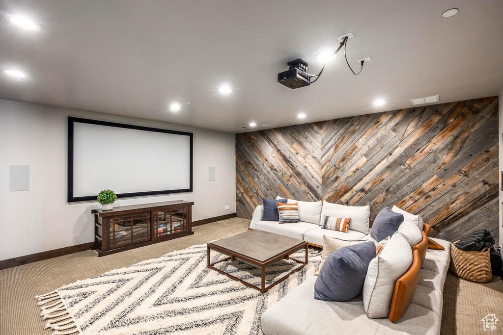 Carpeted home theater featuring wooden walls