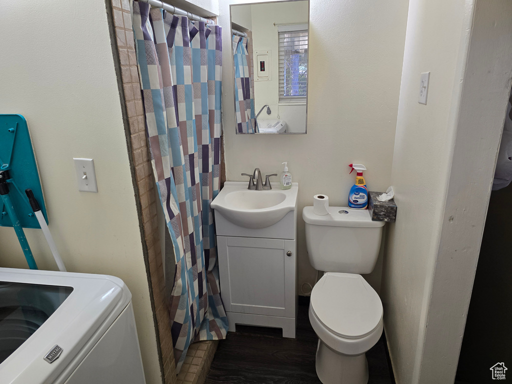 Bathroom with toilet, wood-type flooring, washer / dryer, and vanity