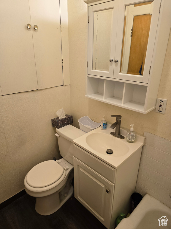 Bathroom featuring toilet, wood-type flooring, and vanity