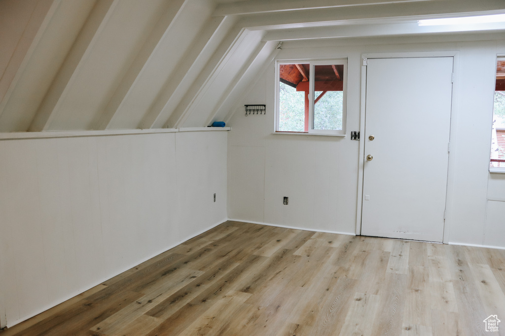 Bonus room with vaulted ceiling and light hardwood / wood-style flooring
