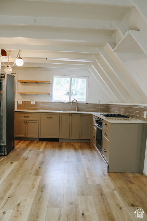 Kitchen with light hardwood / wood-style floors, beamed ceiling, tasteful backsplash, and stainless steel appliances