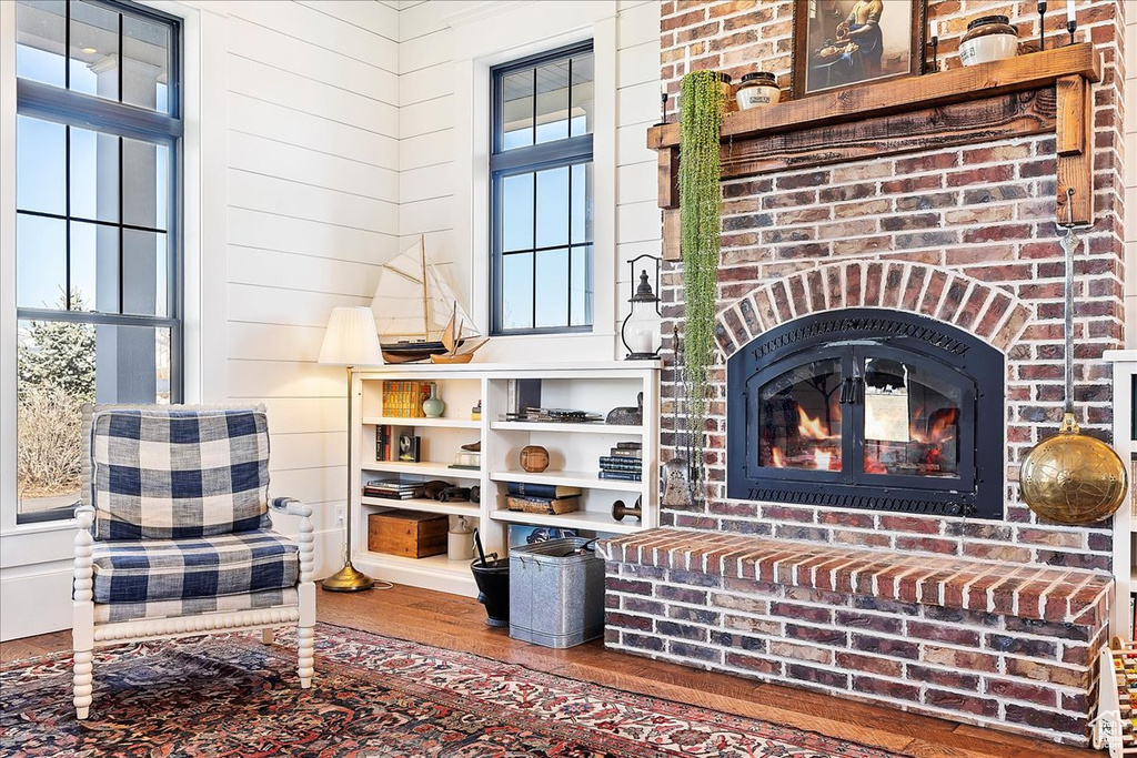 Sitting room with a brick fireplace and dark wood-type flooring