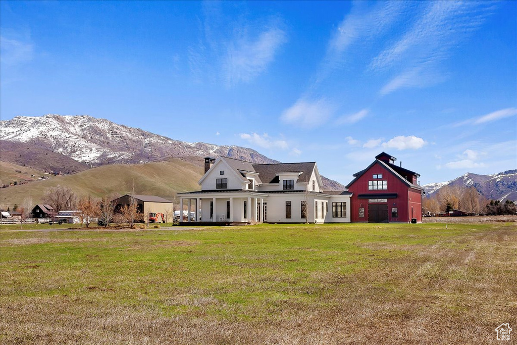 View of front of home with a front lawn and a mountain view