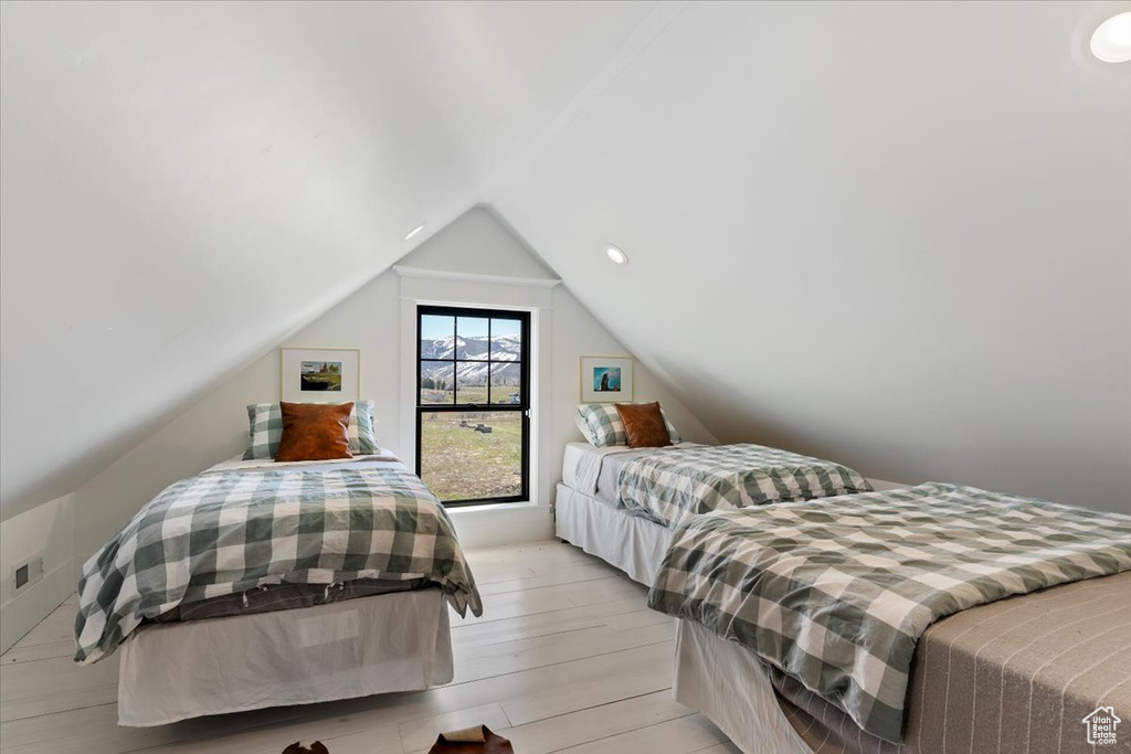 Bedroom featuring vaulted ceiling and light hardwood / wood-style flooring