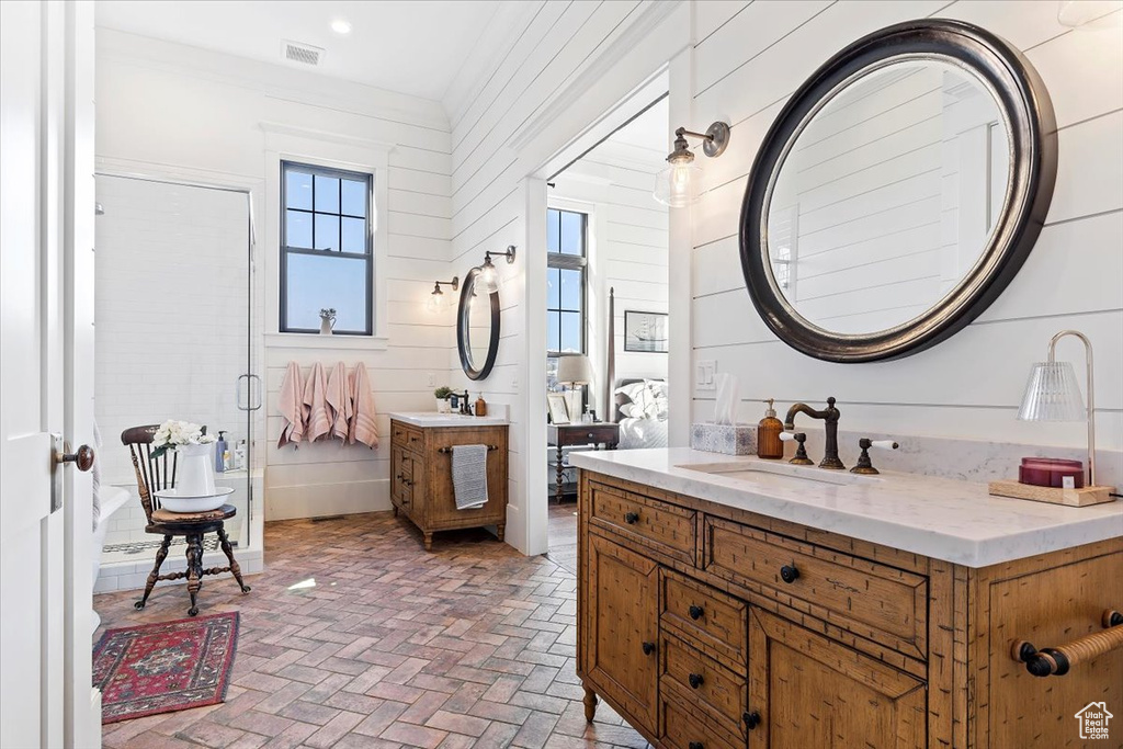 Bathroom with vanity, wood walls, and ornamental molding