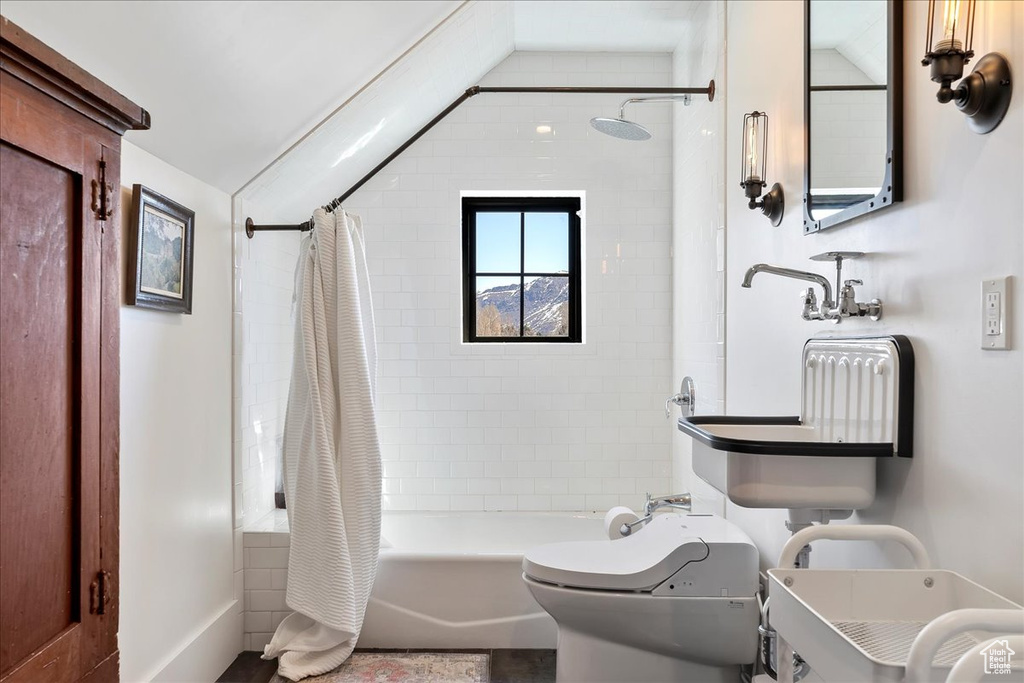 Bathroom with toilet, shower / bath combo with shower curtain, and vaulted ceiling