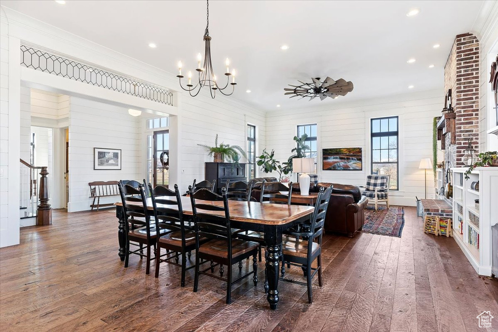 Dining room featuring wood walls, dark hardwood / wood-style flooring, and an inviting chandelier