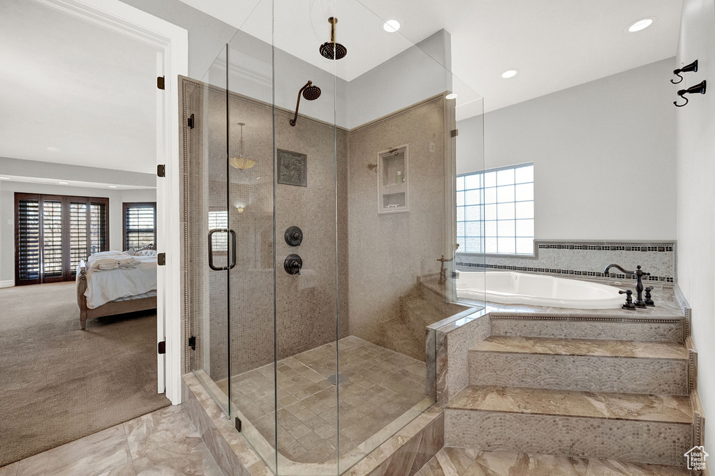 Bathroom featuring plenty of natural light, shower with separate bathtub, and tile flooring