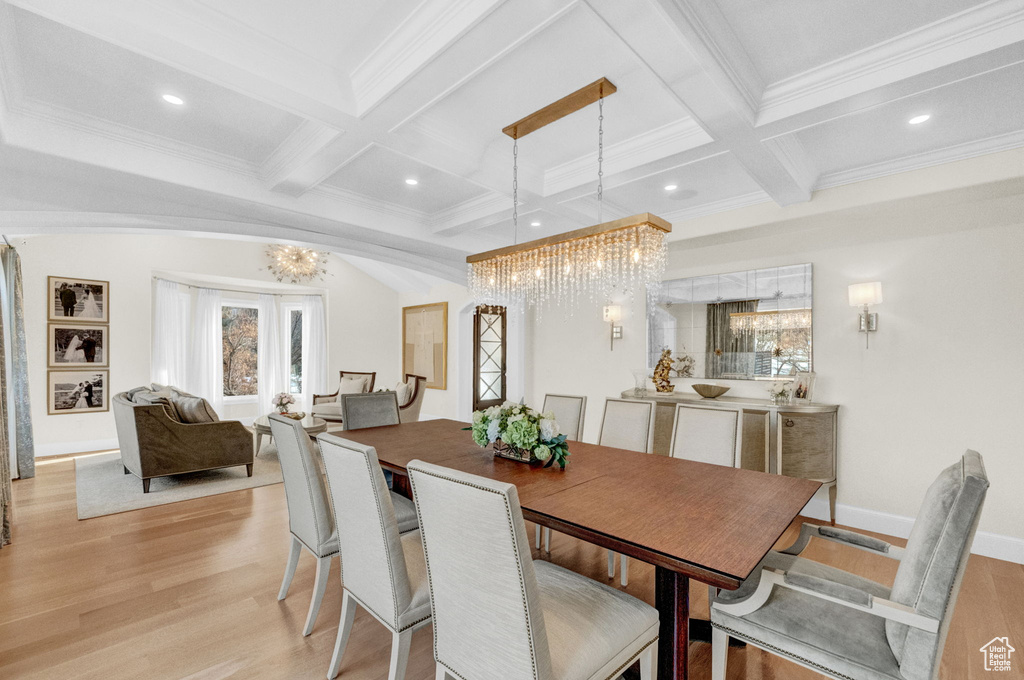 Dining area with coffered ceiling, a chandelier, light wood-type flooring, and beamed ceiling
