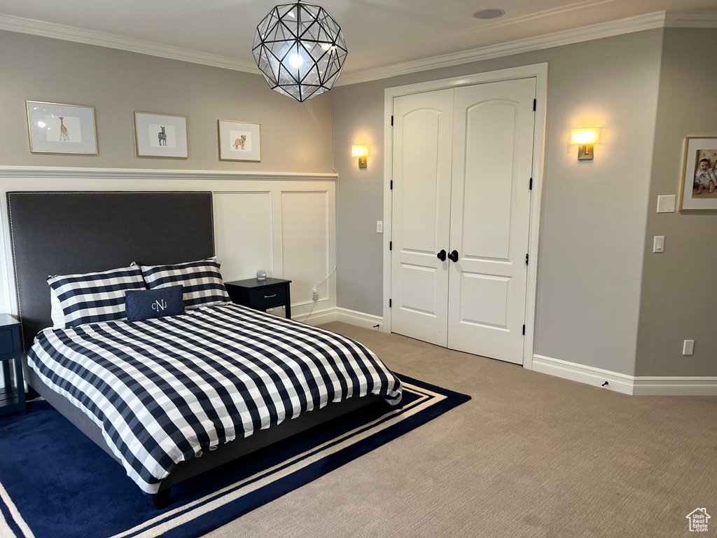 Bedroom featuring ornamental molding, a closet, and light colored carpet