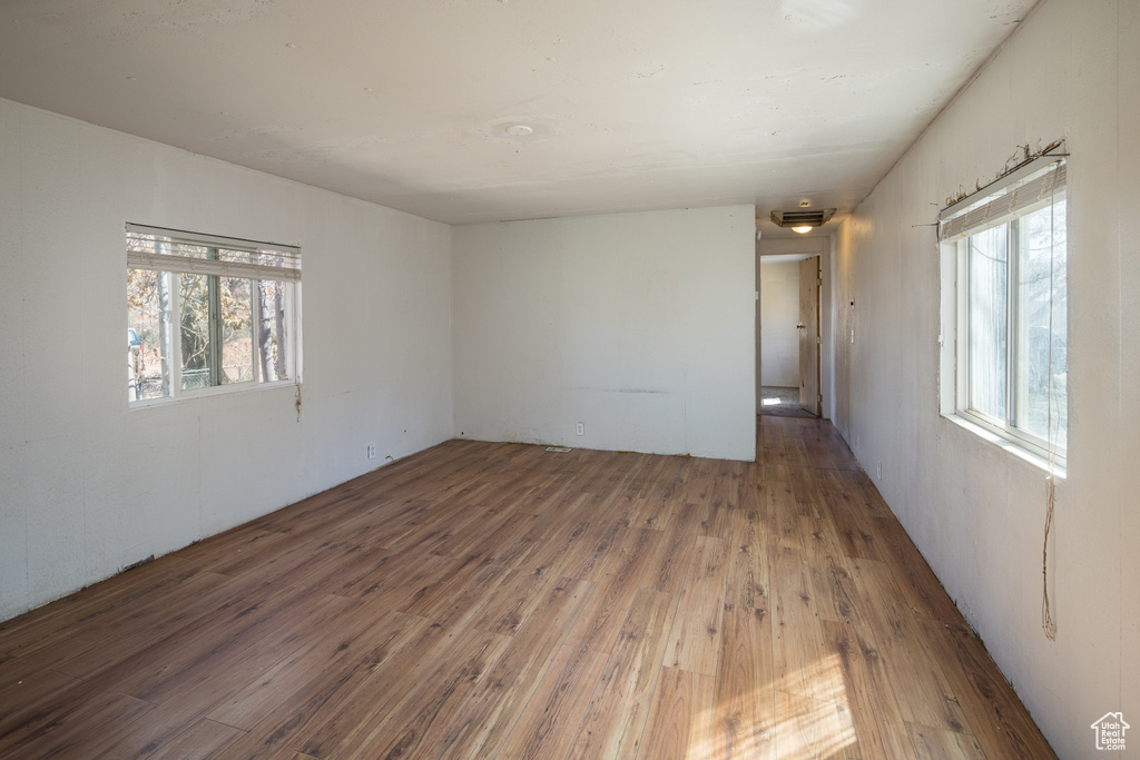 Spare room with a healthy amount of sunlight and dark hardwood / wood-style flooring