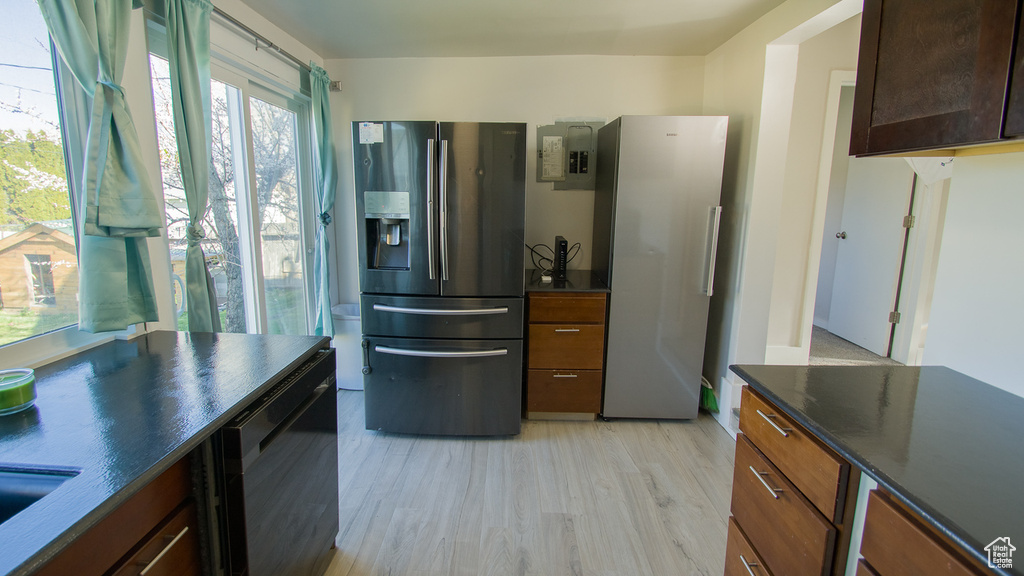 Kitchen featuring black dishwasher, stainless steel fridge with ice dispenser, a wealth of natural light, and light hardwood / wood-style flooring