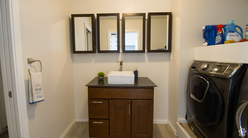 Laundry room with dark hardwood / wood-style flooring, washer / dryer, and sink