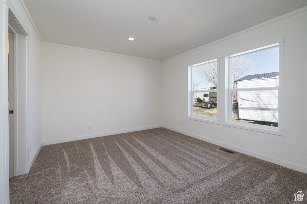 Carpeted spare room featuring ornamental molding