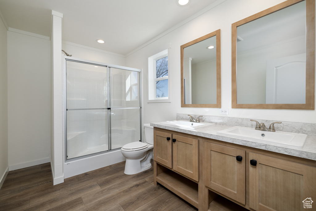 Bathroom featuring double sink, oversized vanity, toilet, and hardwood / wood-style floors