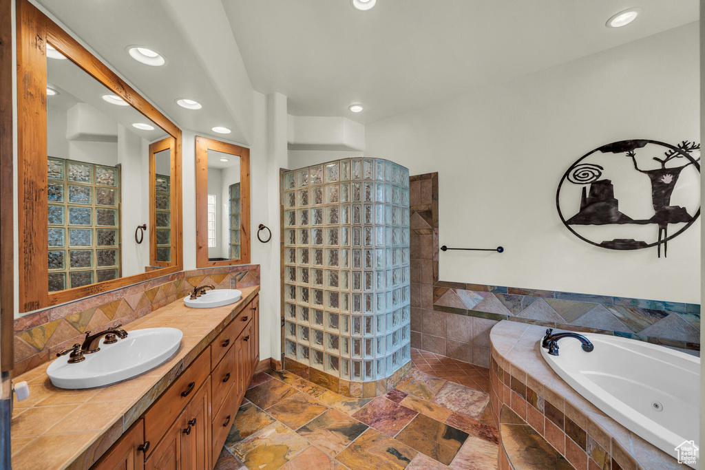Bathroom with double sink, tile flooring, oversized vanity, and tiled bath