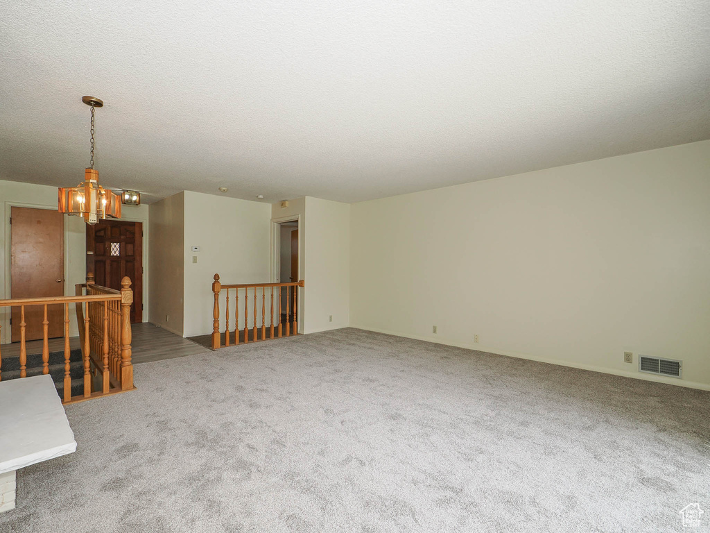 Spare room with a notable chandelier and carpet floors