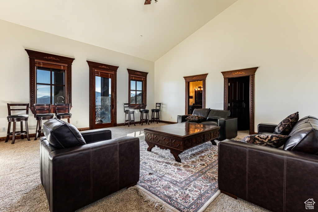 Living room featuring light carpet, high vaulted ceiling, and a wealth of natural light